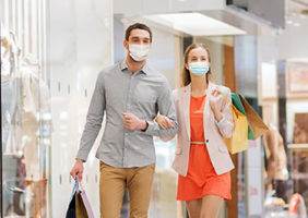 Young couple shopping in mall wearing masks