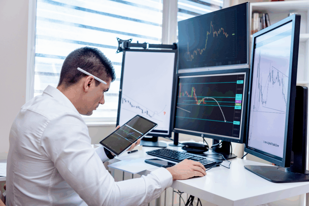 Man sitting at desk monitoring energy levels on multiple screens