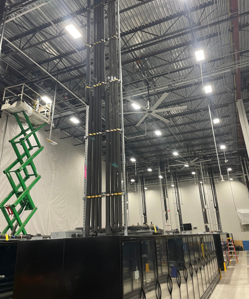 Warehouse with row of refrigeration, piping, and extended lift